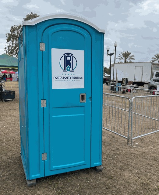 Standard blue porta potty rental unit set up at an outdoor event in Tampa